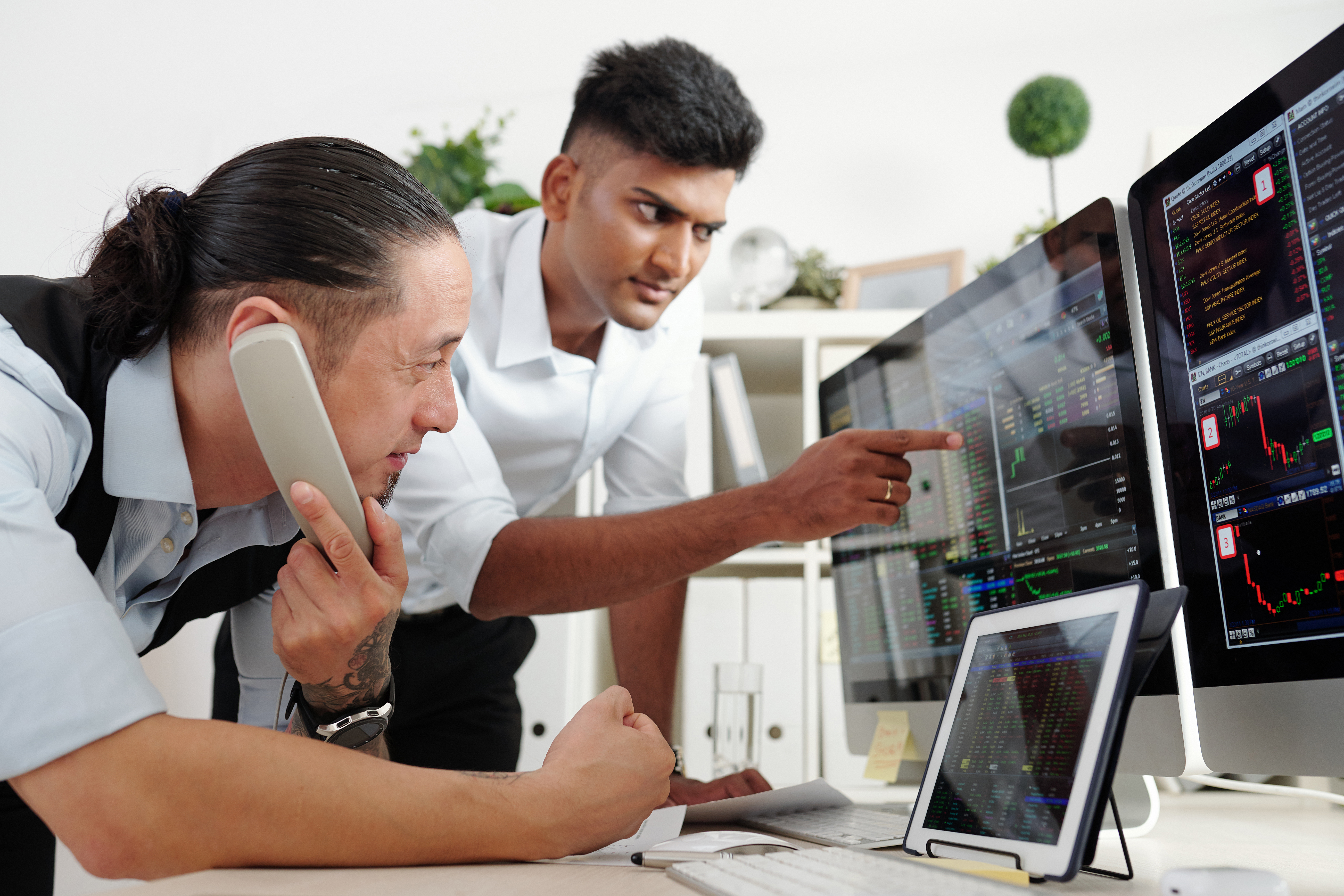 Men monitoring complex data on screens